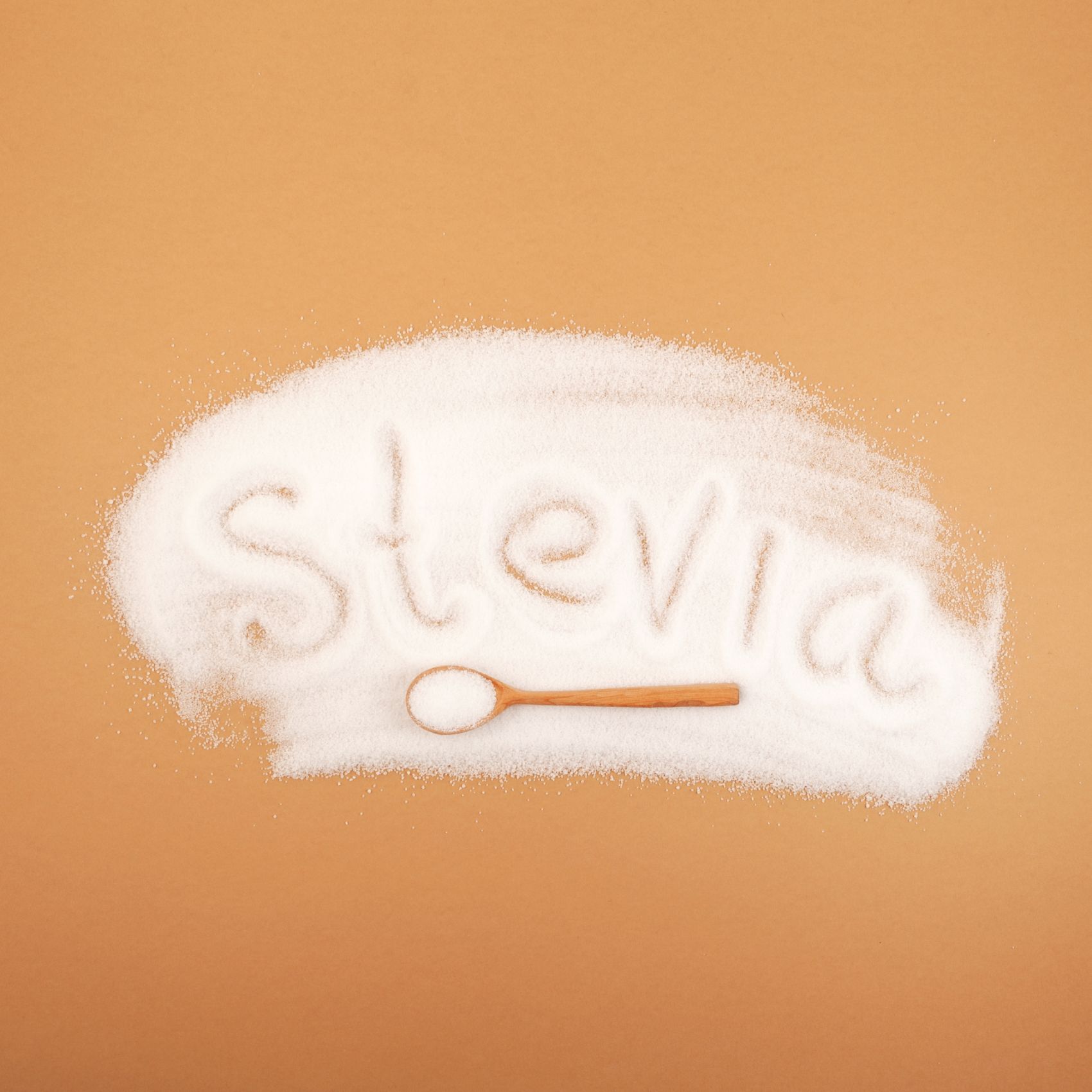 Rozsypane kryształki stevii z napisem stevia
